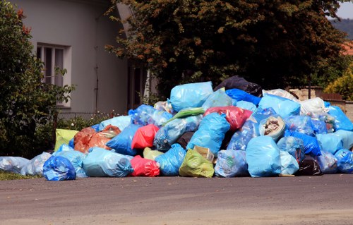 Waste clearance crew loading mixed rubbish from a property in Acton