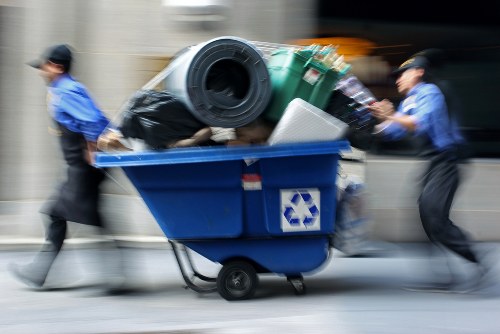 Professional movers carrying bulky items through an Acton flat corridor